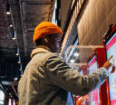 Customer ordering their meal off of a self-serve touchscreen kiosk.