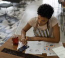 A restaurant owner reviewing their business’ data analytics reports and calculating profits.